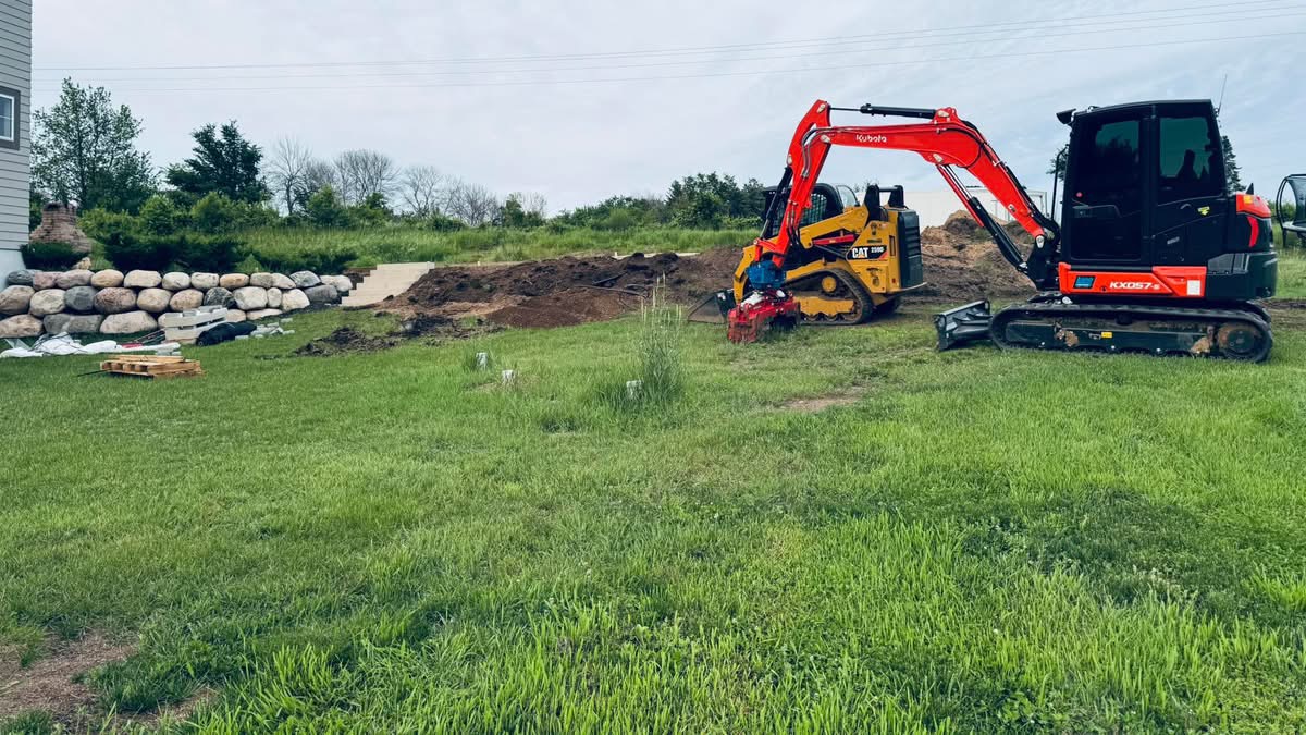 Kubota excavator and Cat skid steer working a backyard site