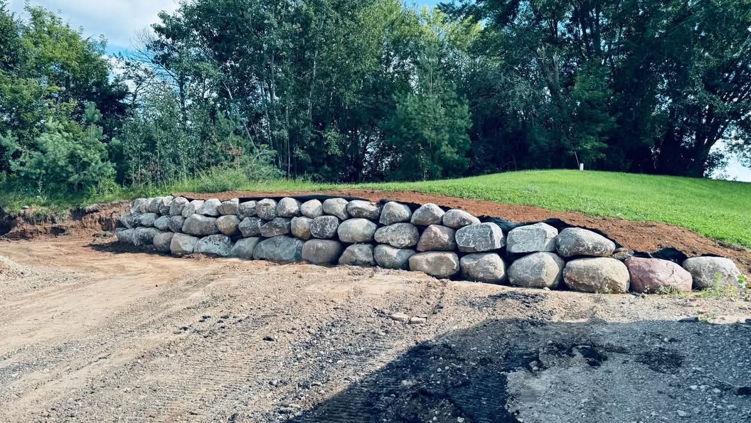 Boulder retaining wall along driveway